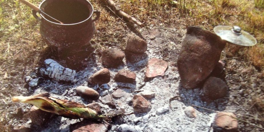 Historic cooking implements around coals