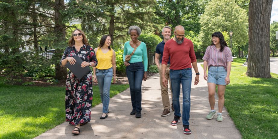 A guide leads a group down the sidewalk