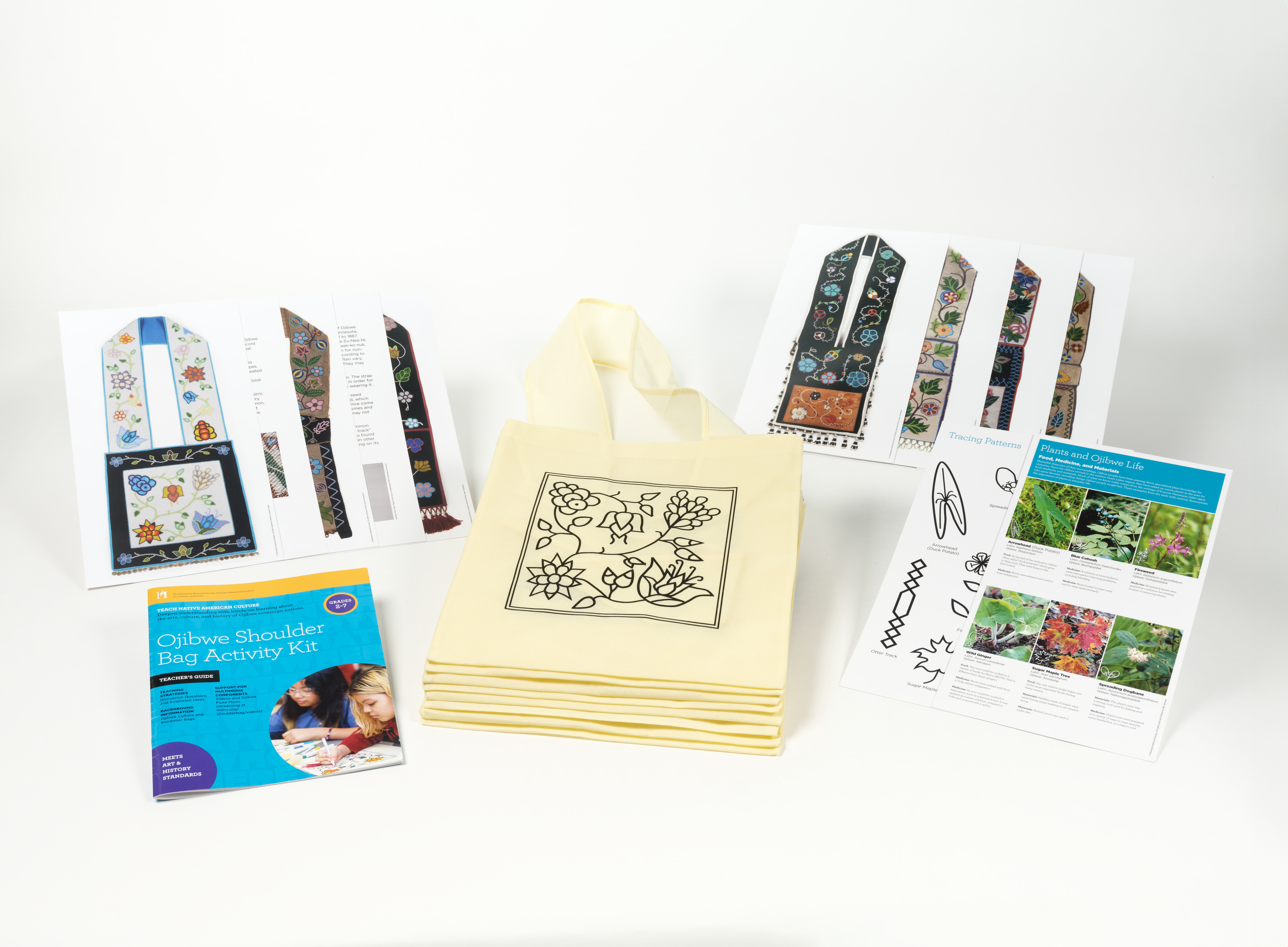 A photo of the Ojibwe Shoulder Bag kit showing a stack of bags, an activity booklet and placards that come with the kit.
