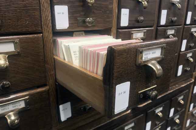 Drawer of library card catalog extended out of cabinet.